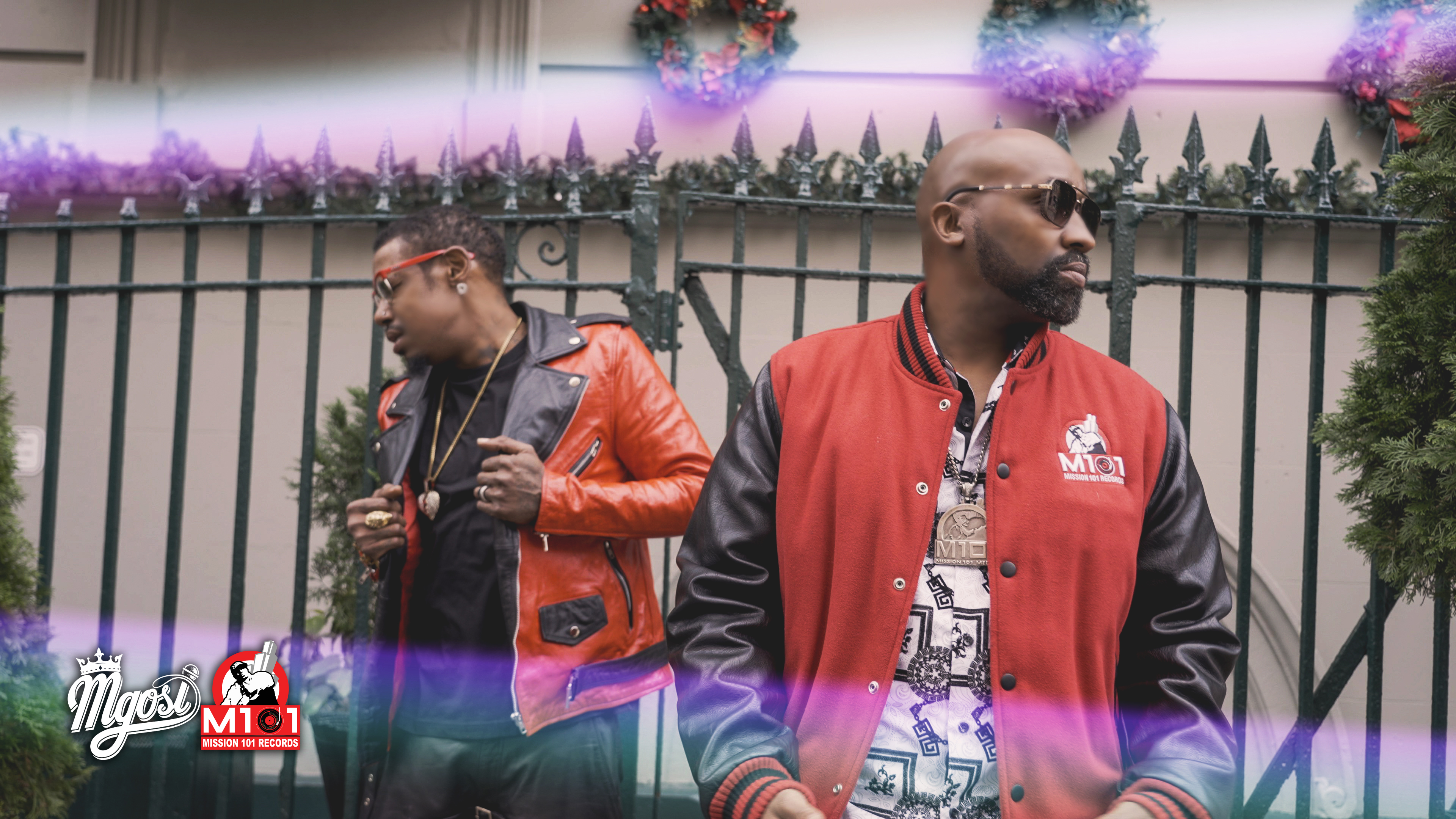Mgosi and Robert Curry in red and black jackets beside festive holiday decorations